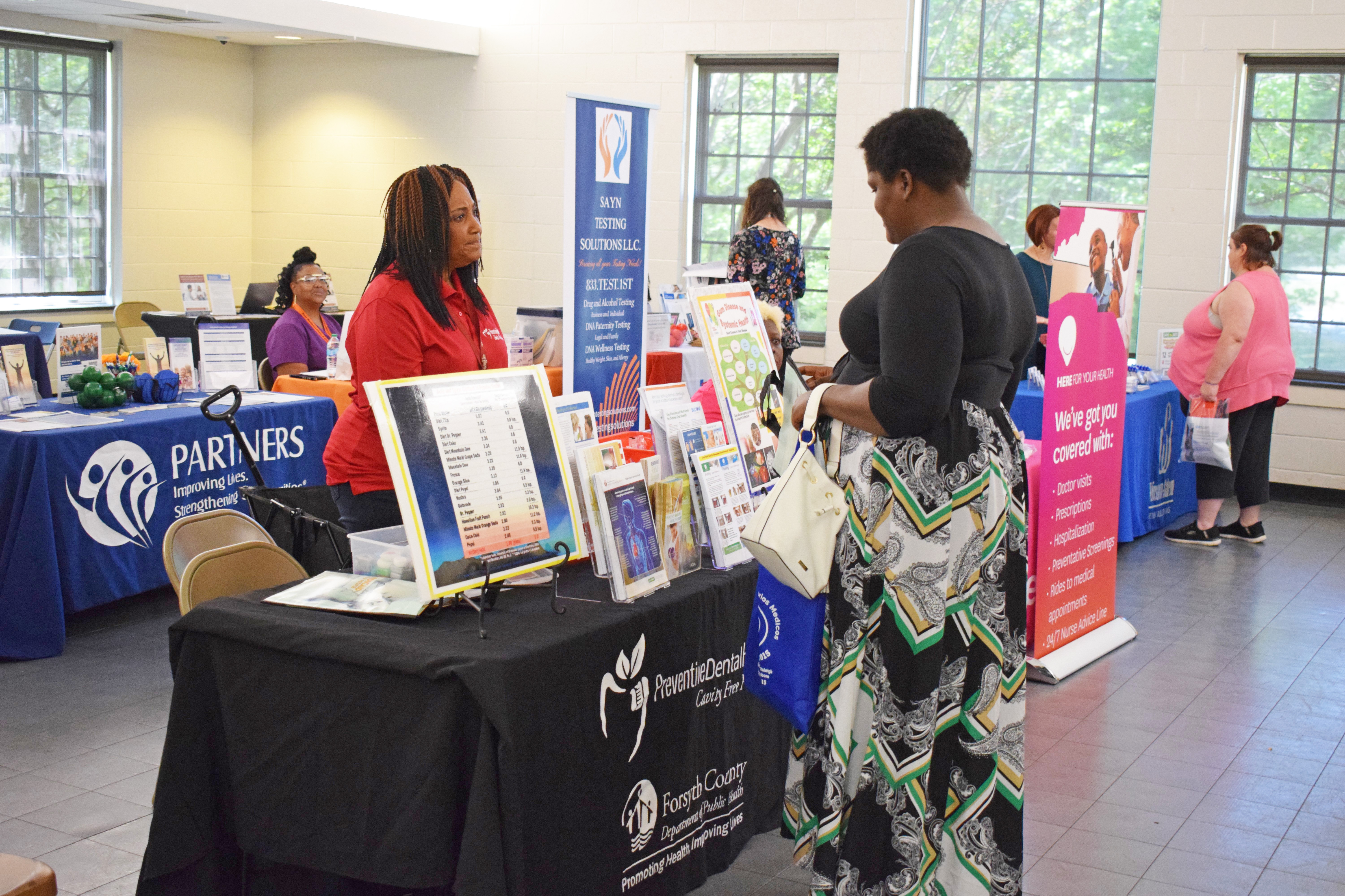 Public Health employees talking to a resident at a health fair